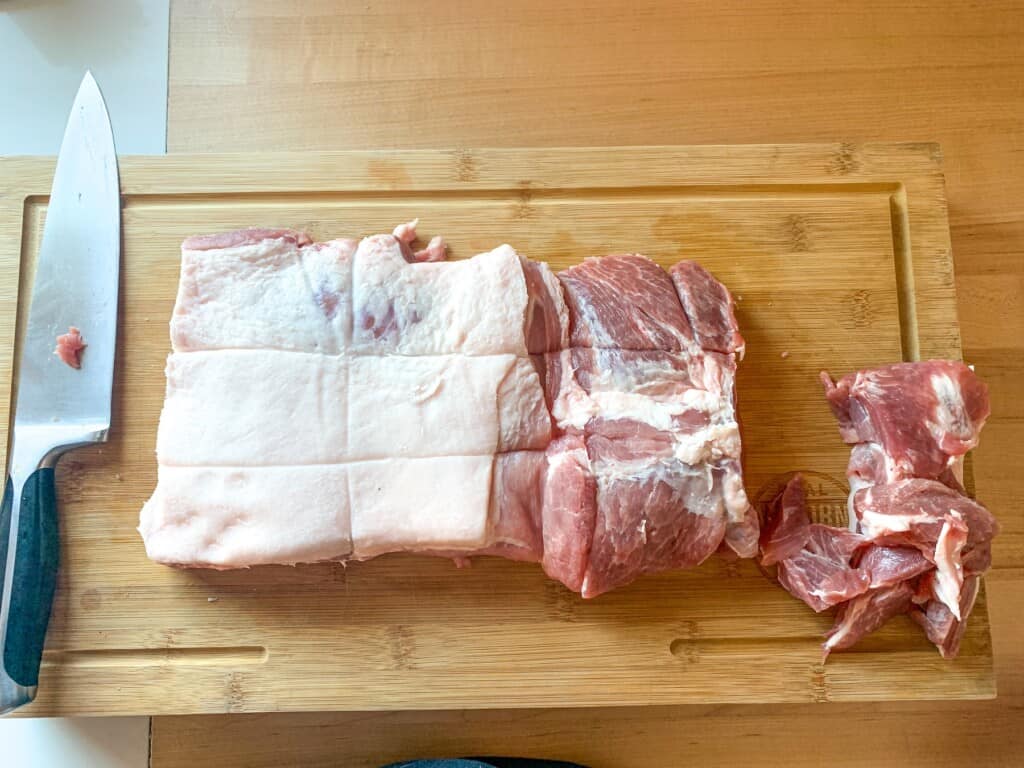 The pork roast on a cutting board with a knife next to it. 