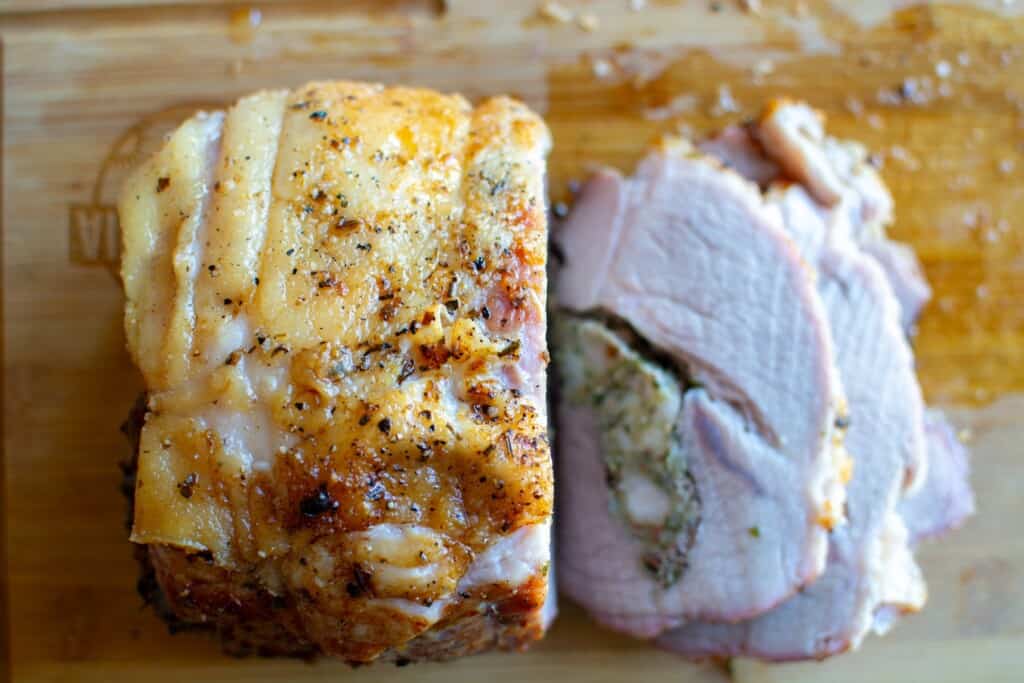 A pork roast sliced on a wood cutting board