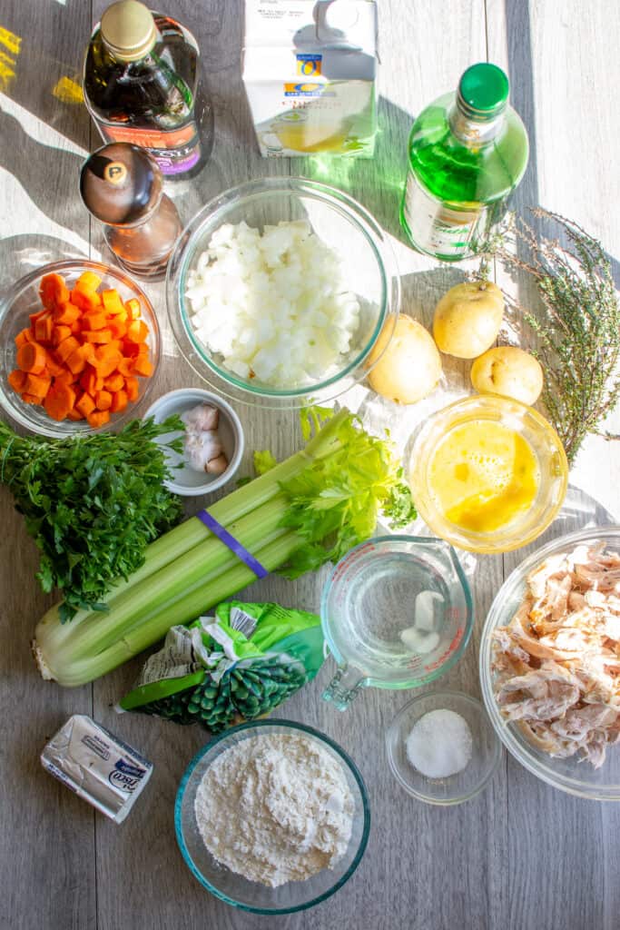 All the ingredients to make dairy-free chicken pot pie including shredded chicken, flour, salt, crisp, frozen peas, and more. 
