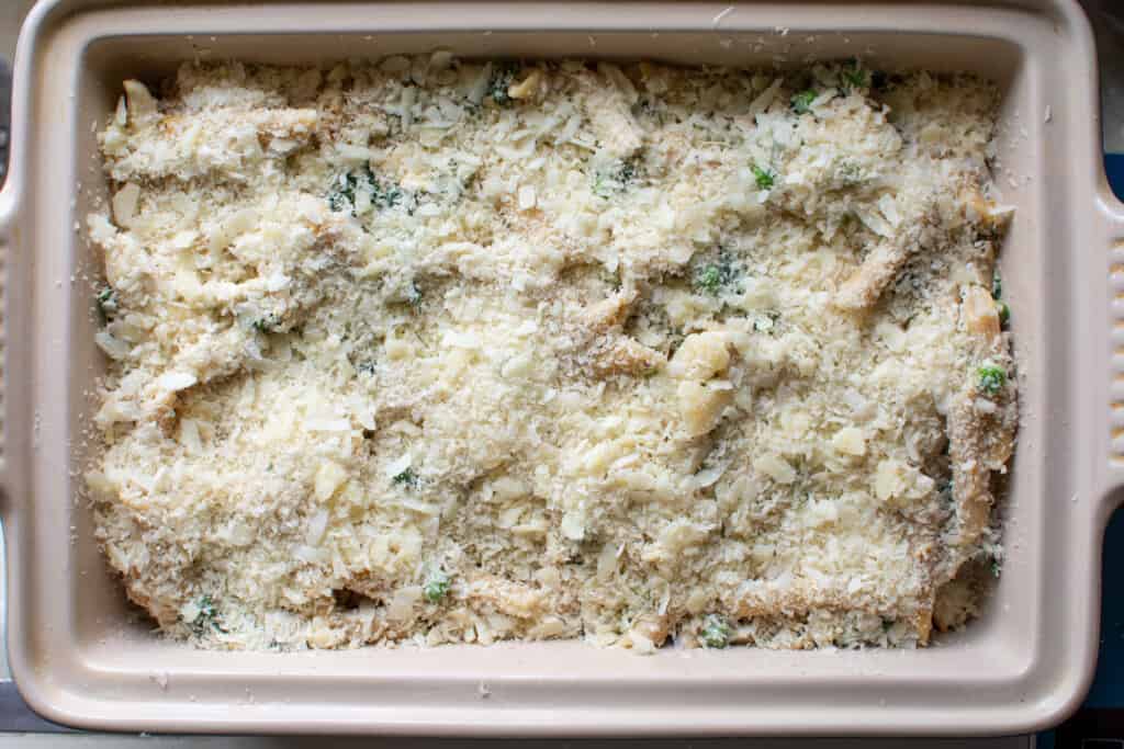 A baking dish of chicken noodle casserole prepared to be baked in the oven with bread crumbs on top. 