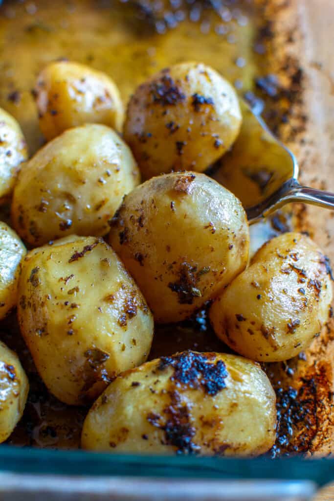 A baking dish of roasted baby potatoes that are golden brown. 