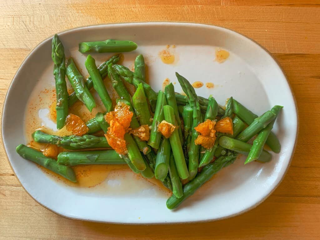 an oval platter with asparagus on it