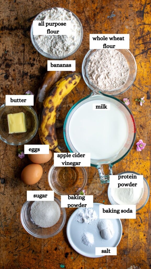 all the ingredients to make banana protein pancakes including flour, whole wheat flour, bananas, protein powder and more. 