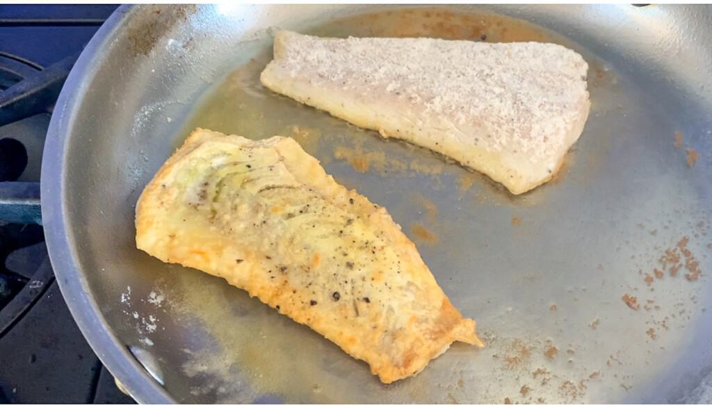 fish pan searing in a metal skillet 