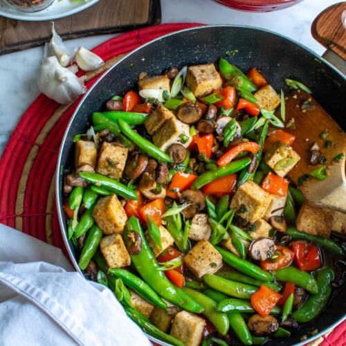 A black frying pan filled with tofu stir fry.