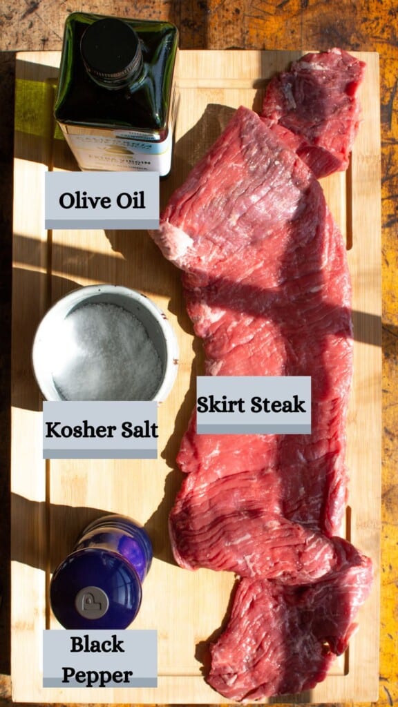 All the ingredients needed to make skirt steak including olive oil, skirt steak, salt, and black pepper. 