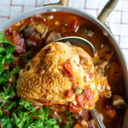 a close up of chicken cacciatore with parsley on top