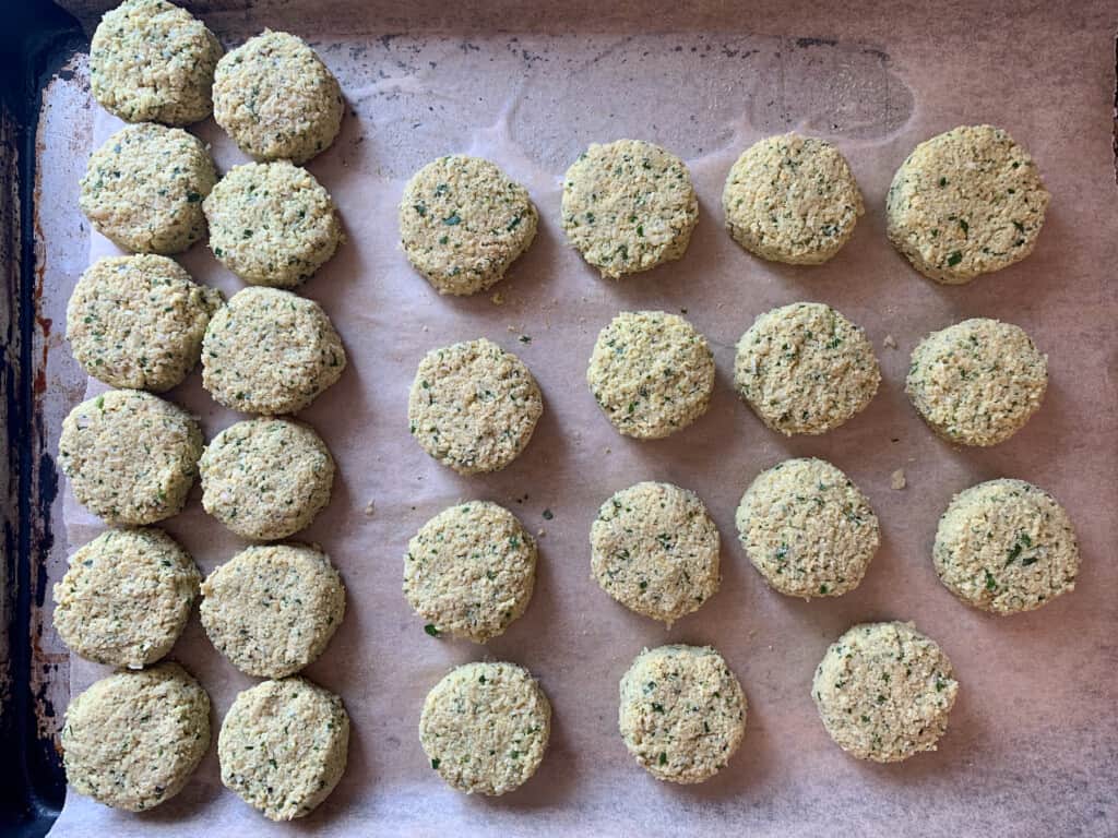 Falafel patties on a parchment-lined baking sheet.