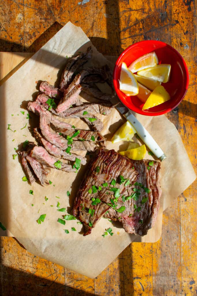 Cooked skirt steak on a piece of parchment paper. 