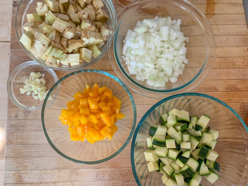 All the veggies to make vegan bolognese chopped and separated into glass bowls. 