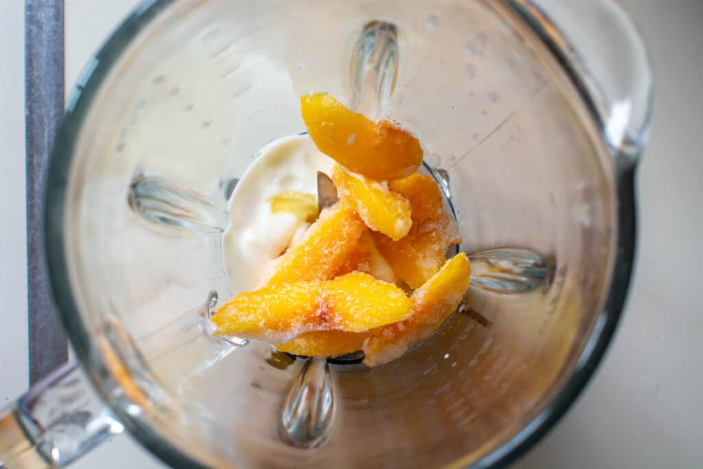 Frozen peaches and yogurt in a blender. 