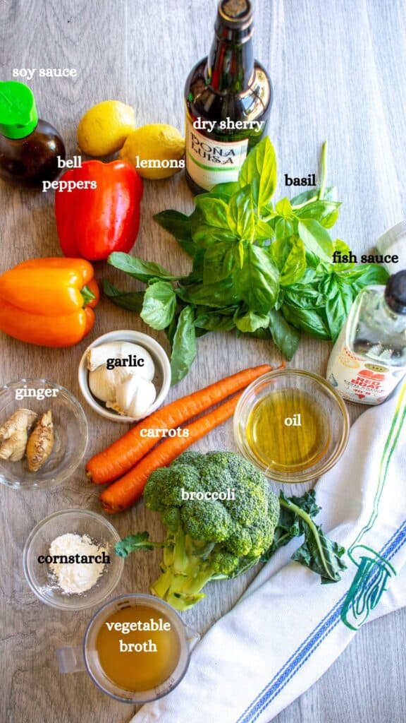 All the ingredients to make vegetable stir fry recipe including sherry, soy sauce, lemons, peppers, fish sauce, and more. 