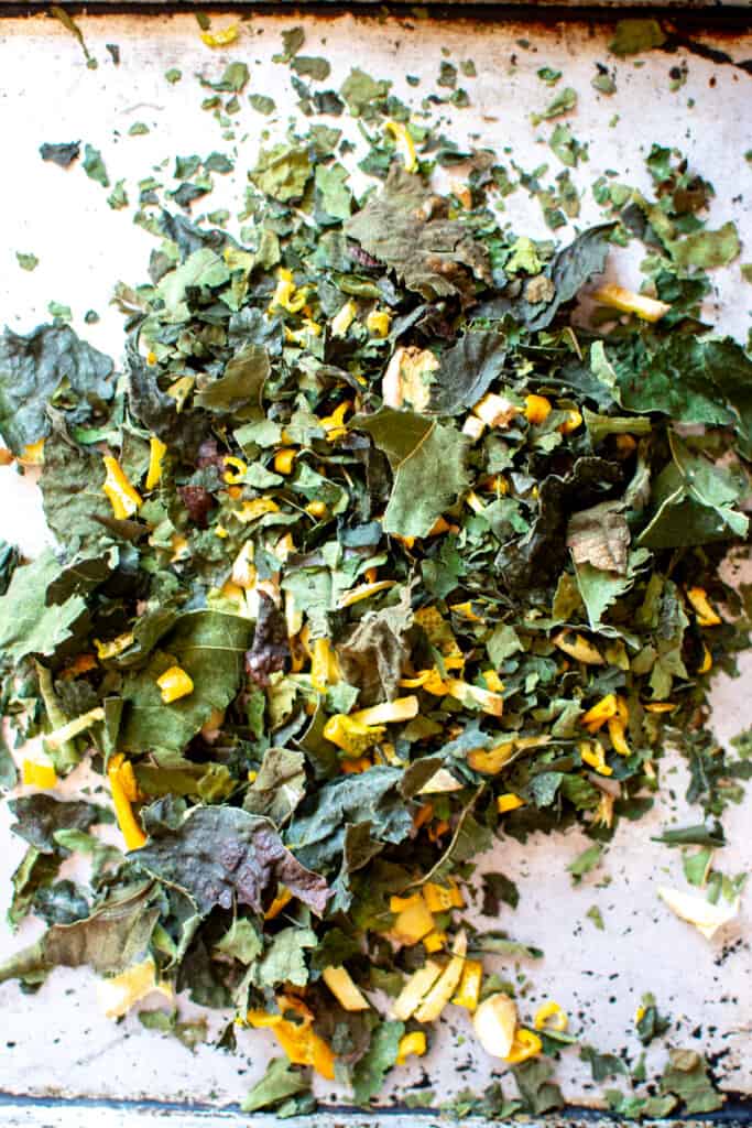 Fig leaf tea on a baking sheet after being crumbled.