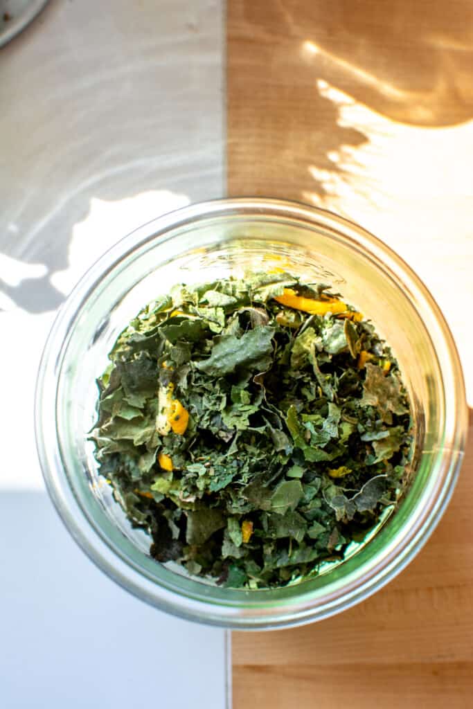 A jar of fig leaf tea on a counter.
