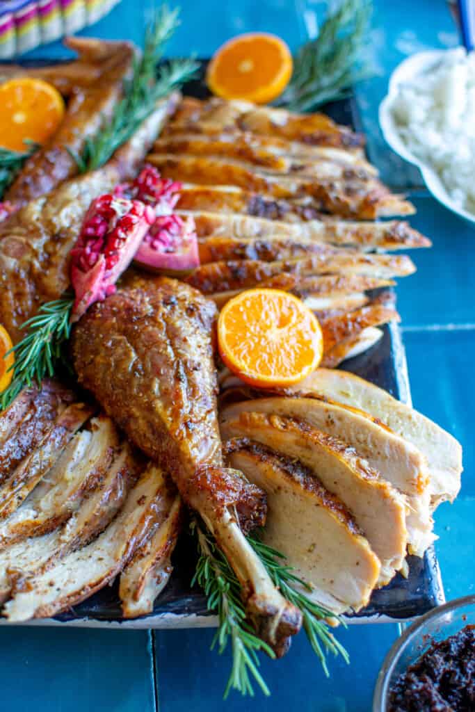 A platter of carved turkey on a blue tile table 