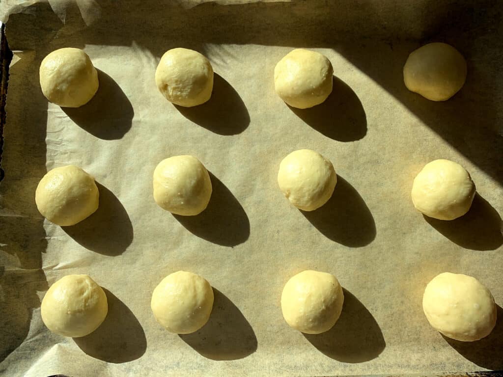 dough balls on a parchment lined baking sheet. 