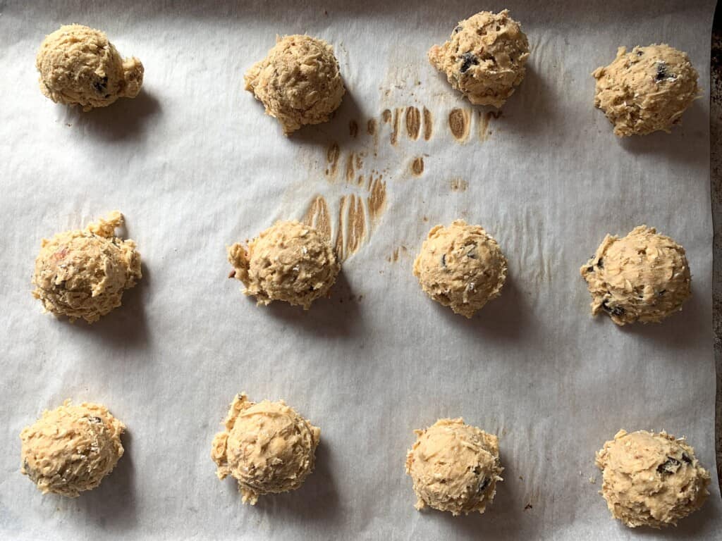Balls of cookie dough on a parchment-lined baking sheet
