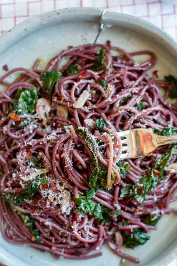 A bowl of zinfandel spaghetti with a fork in the bowl. 