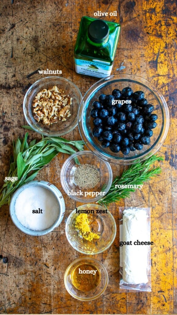 All the ingredients to make the goat cheese dip including goat cheese and black grapes. 