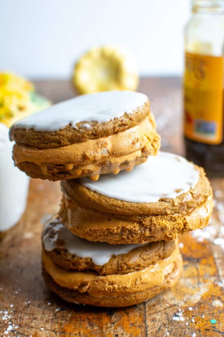 A stack of pumpkin ice cream sandwiches on a wood table.