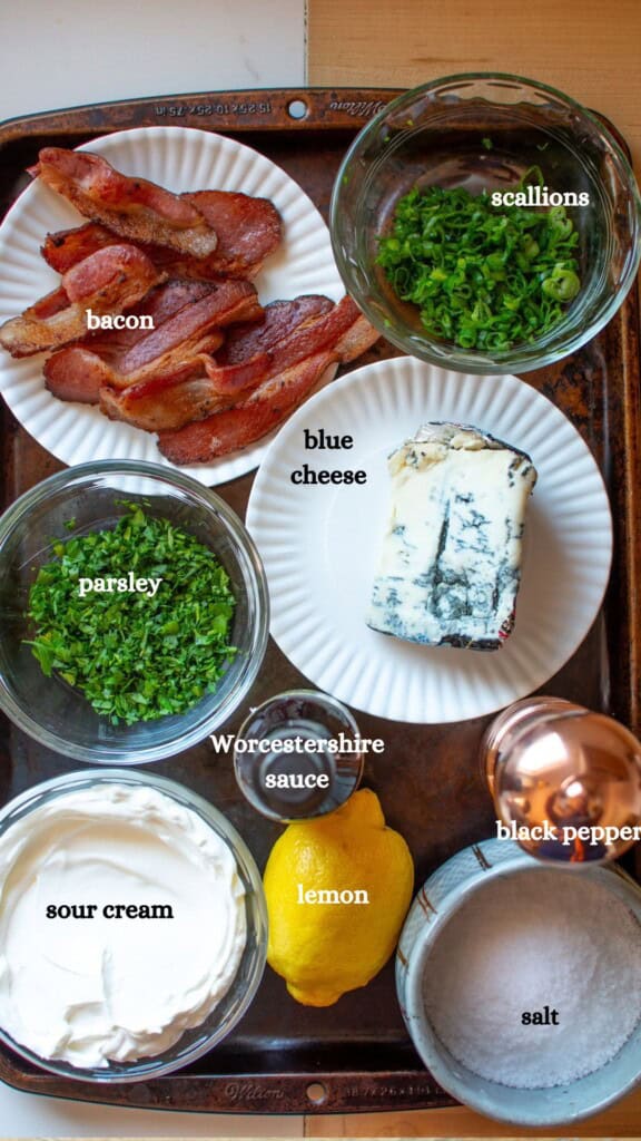 All the ingredients to make bacon blue cheese dip on a baking tray. 