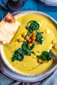 A bowl of butternut squash soup topped with spinach