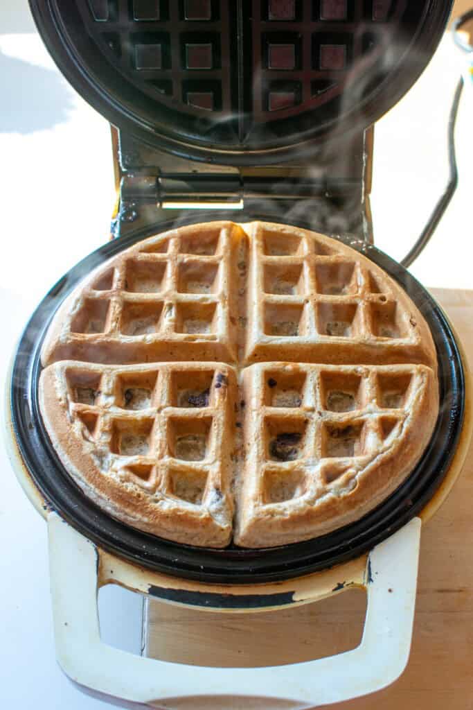 A waffle in the waffle iron after being cooked. 