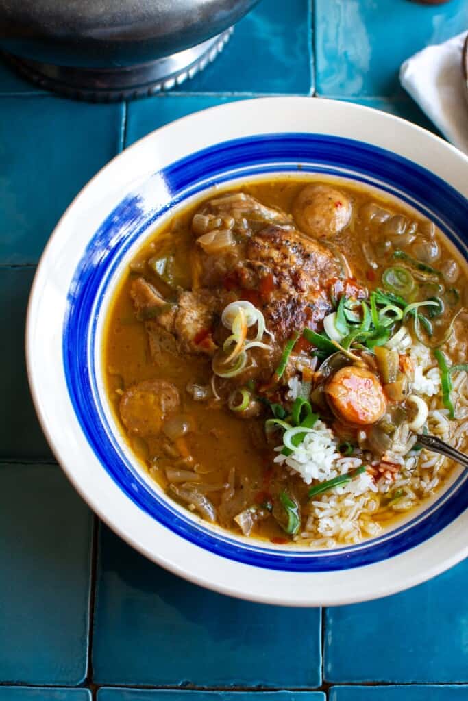 A bowl of gumbo with a spoon in the bowl. 