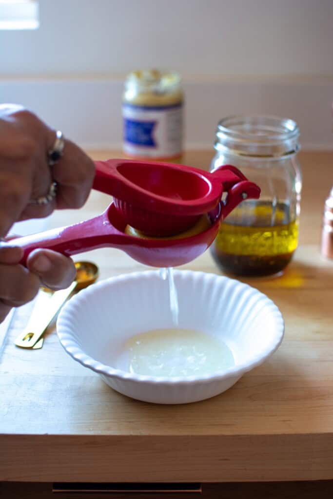 a lemon being squeezed with a lemon squeezer