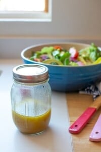 A mason jar with maple mustard salad dressing in it.