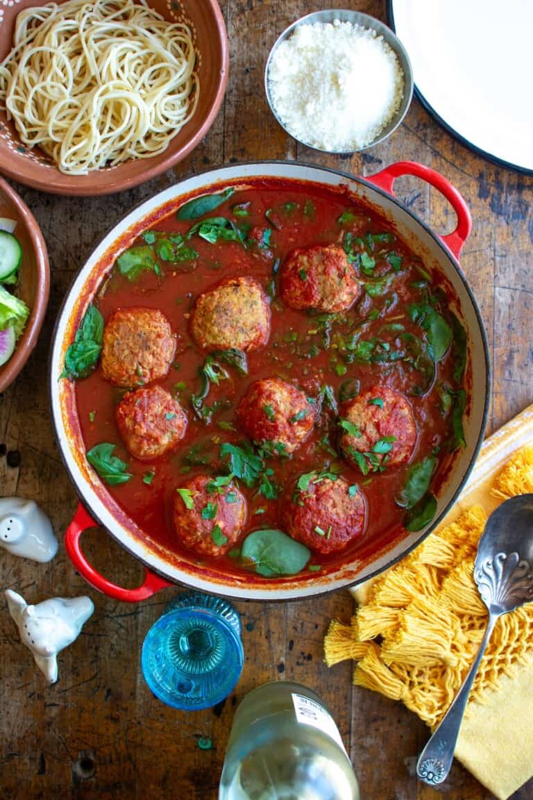 A pot of chicken puttanesca meatballs on a table.