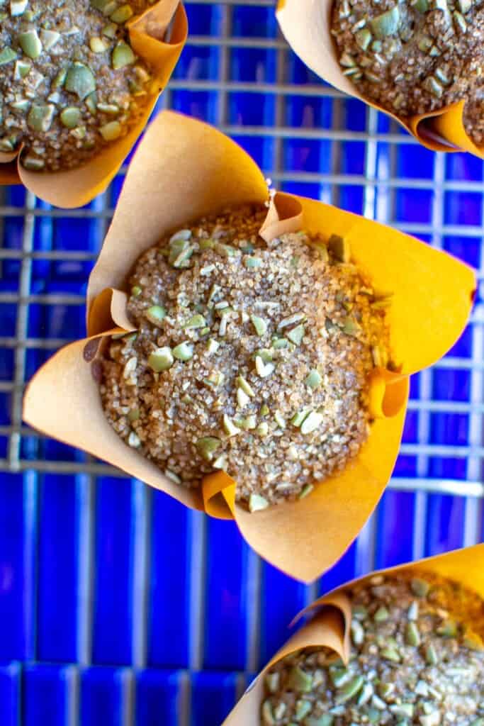 A pumpkin seed muffin on a blue tile table. 