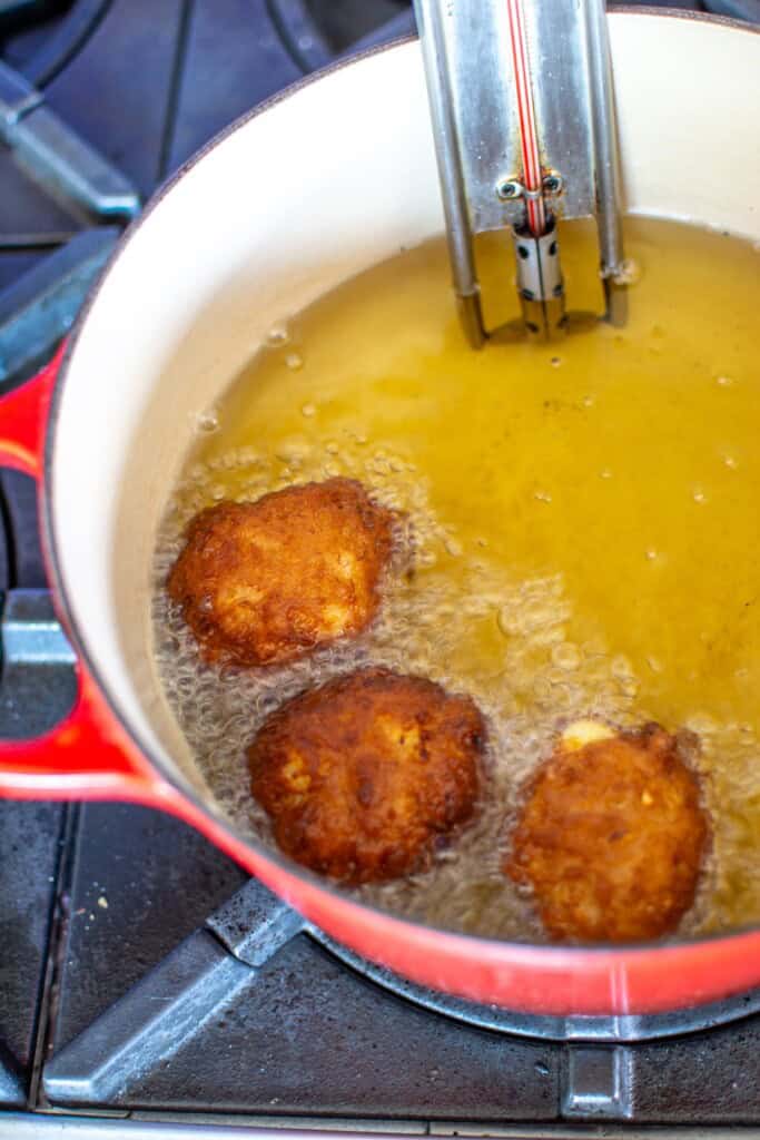 Several fritters frying in hot oil