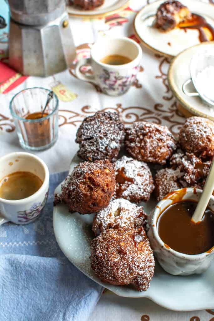 A platter of peanut butter banana fritters with a jar of caramel sauce