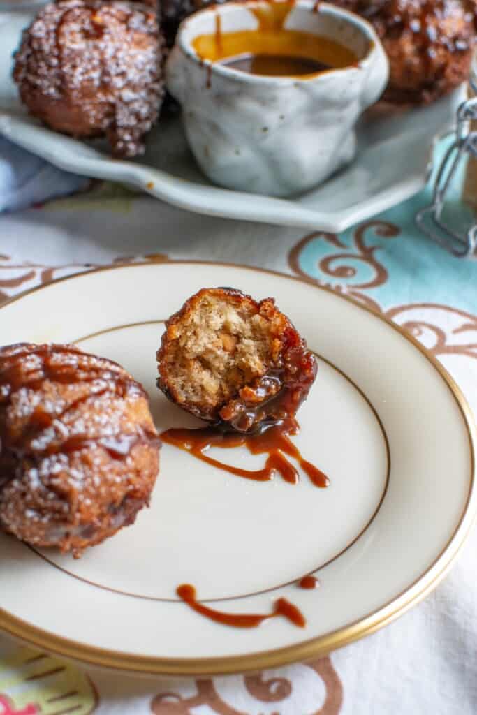 A peanut butter banana fritter with caramel sauce on it. 