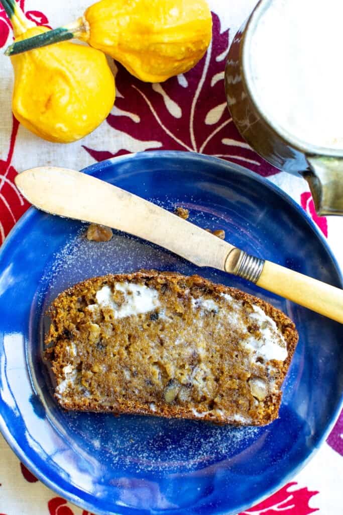 a piece of pumpkin walnut bread on a blue plate
