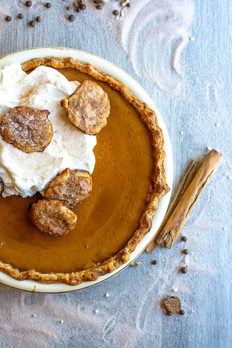 A pumpkin pie topped with whipped cream