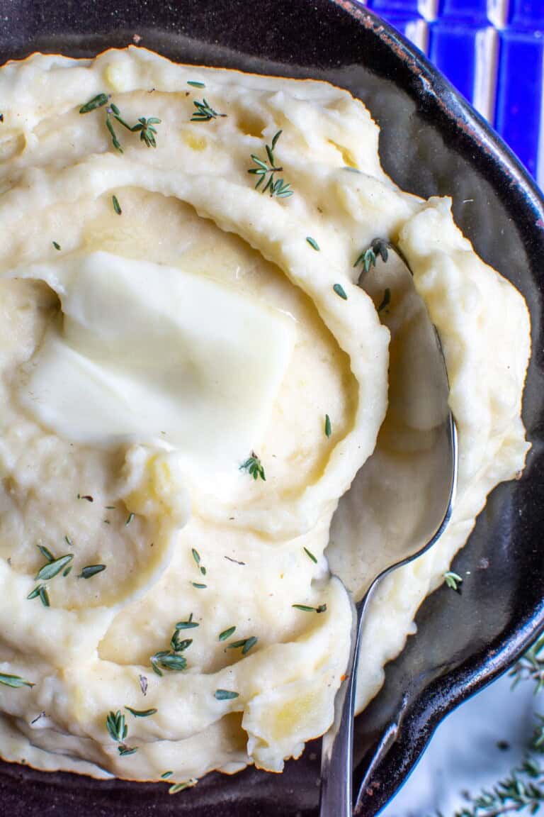 a bowl of mashed potatoes with a pat of butter melting on top