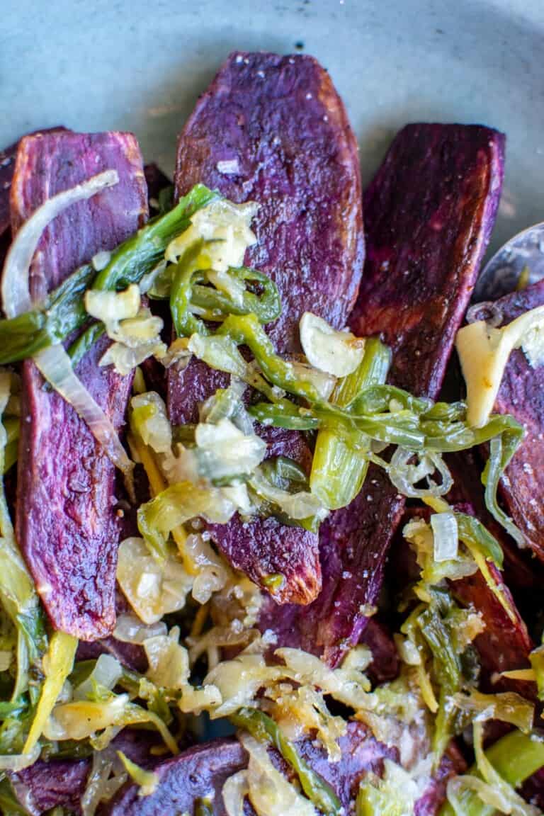 baked purple sweet potatoes topped with sautéed shallots