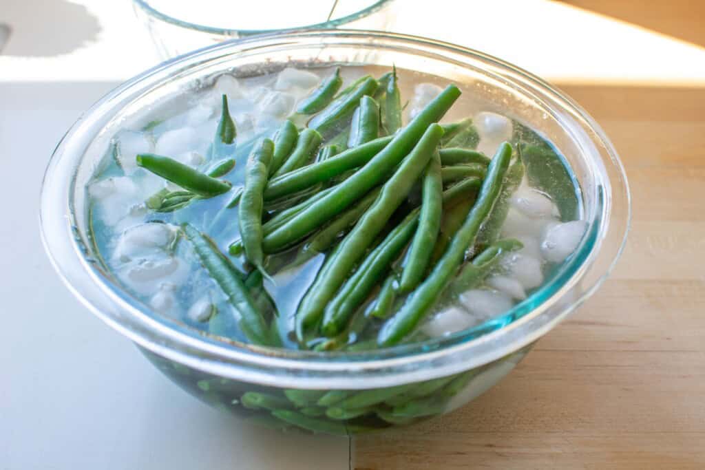 The green beans soaking in a bowl of ice water