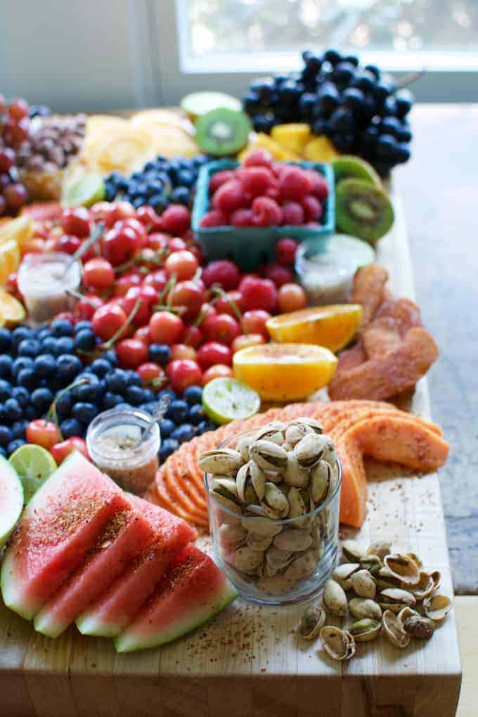 A wooden board with a ton of fruit on it.
