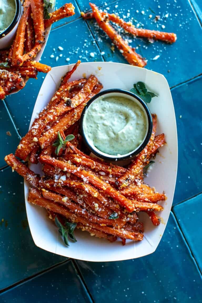 a basket of carrot fries with pesto aioli