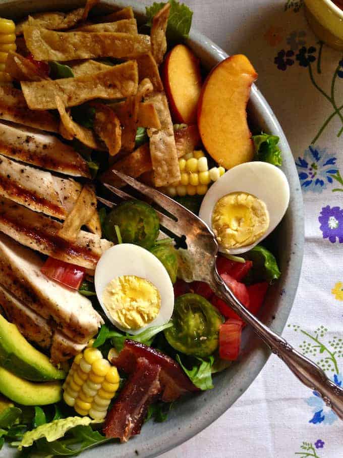 a salad with grilled chicken sliced on top