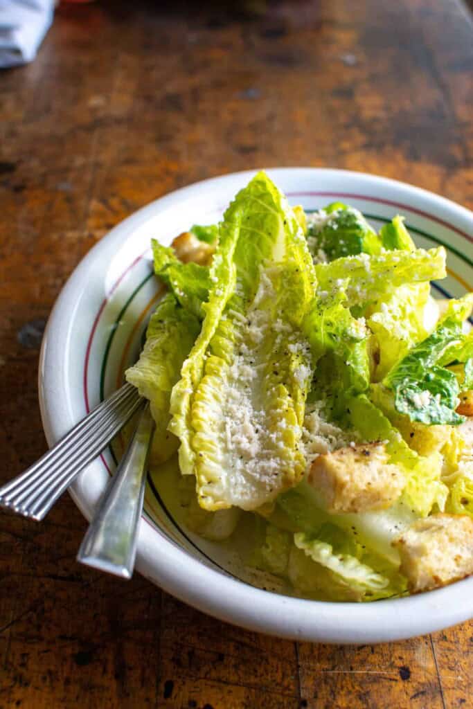 a caesar salad with grated parmesan on top