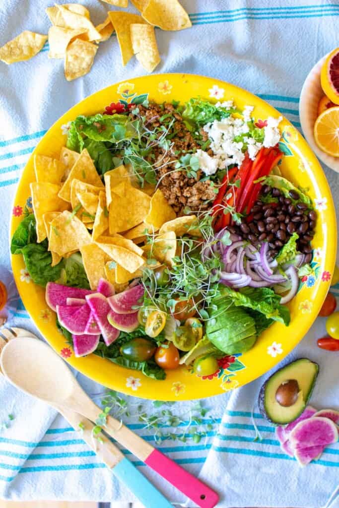 A big salad with tortilla chips on top