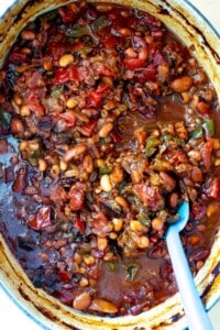 calico baked beans in a pot with a blue spoon