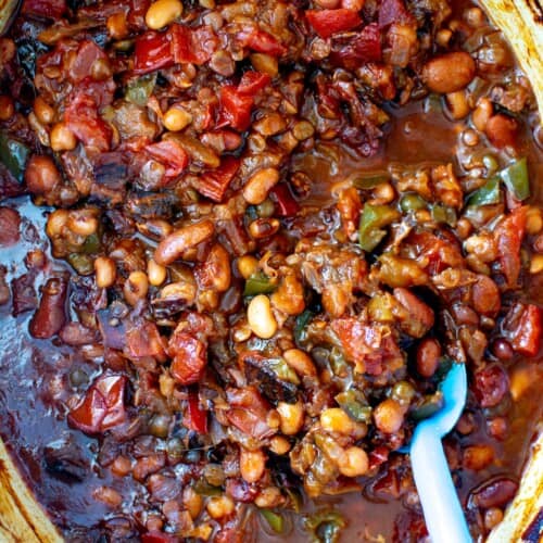 calico baked beans in a pot with a blue spoon