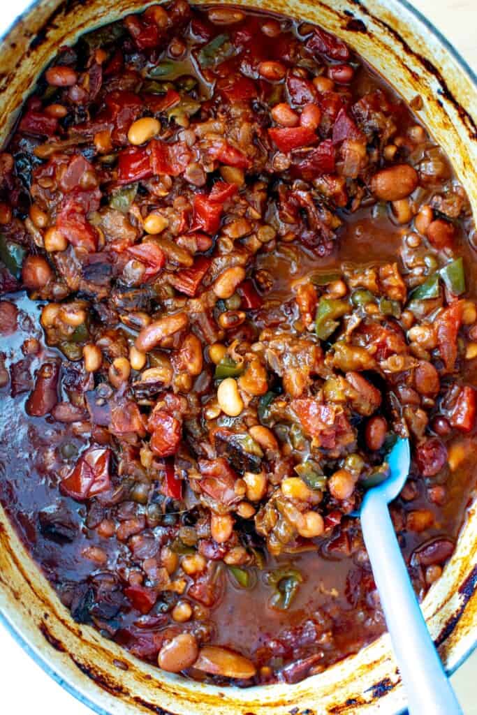 calico baked beans in a pot with a blue spoon