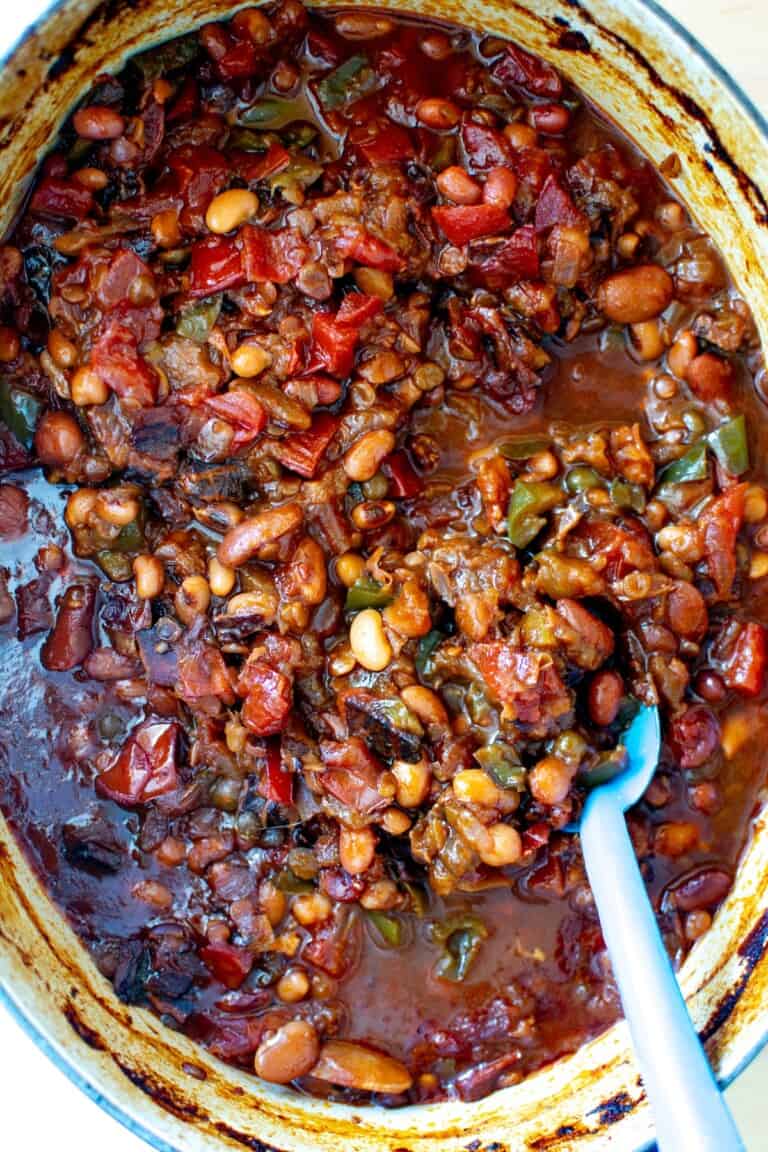 calico baked beans in a pot with a blue spoon