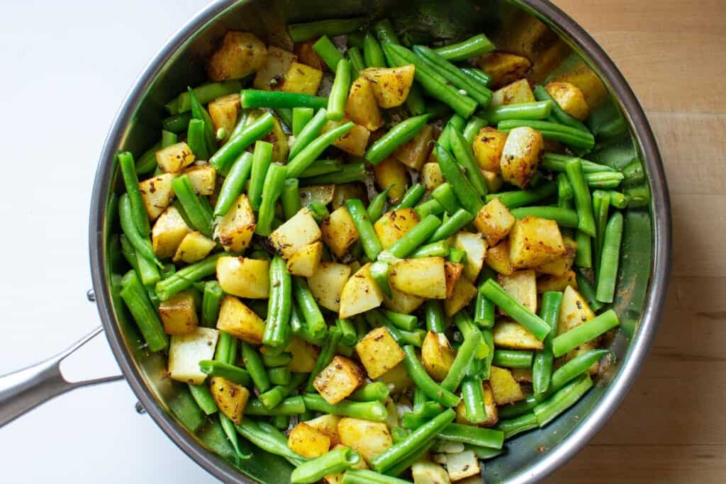 potatoes and green beans in a frying pan
